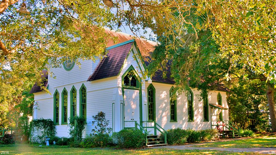 Andrew's Memorial Chapel, a white chapel with green trim beneath sunlit trees