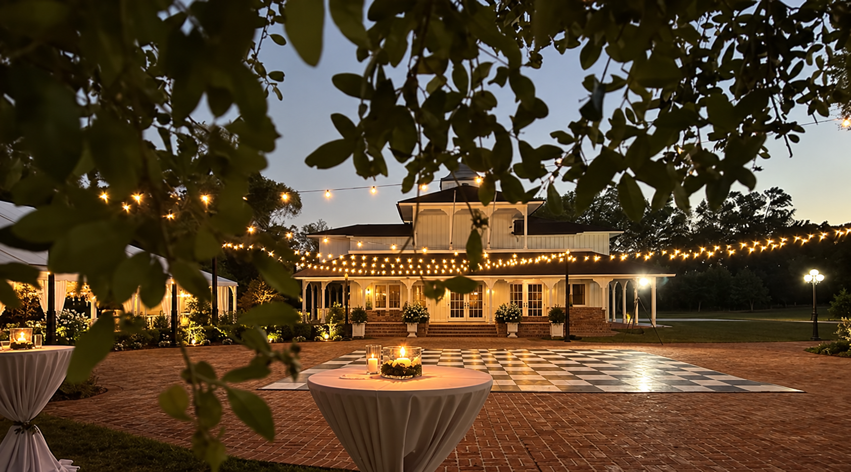 The Estate at dusk with string lights and an empty black and white checkerboard dance floor